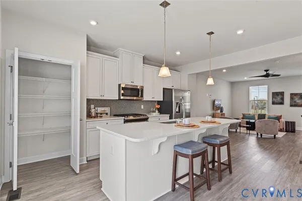 a kitchen with stainless steel appliances a stove a sink a dining table and chairs