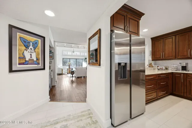 a kitchen with stainless steel appliances a dining table chairs and wooden floor