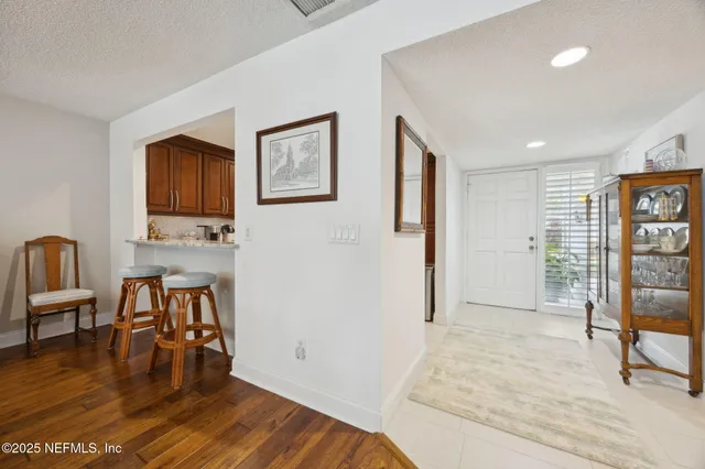 a living room with furniture floor to ceiling window and wooden floor