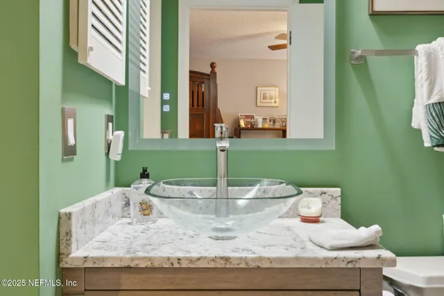 a bathroom with a granite countertop double vanity sink and shower