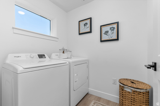 1352 West 2350 South, Unit 18 Perry, UT 84302 - Photo 16 of 26 Dedicated laundry space featuring a white top-load washing machine and dryer, a horizontal window, white walls, and wood-finish flooring