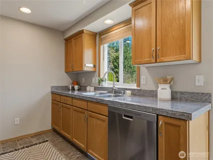 a kitchen with stainless steel appliances granite countertop a sink a stove and a cabinets