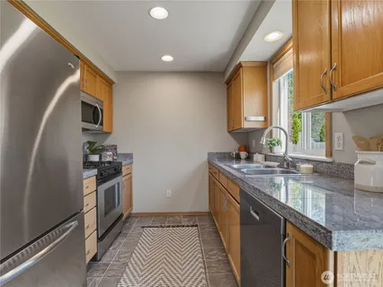 a kitchen with stainless steel appliances granite countertop a sink stove and refrigerator