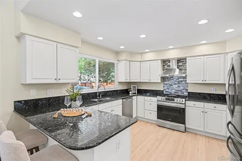a kitchen with stainless steel appliances granite countertop a sink stove and cabinets