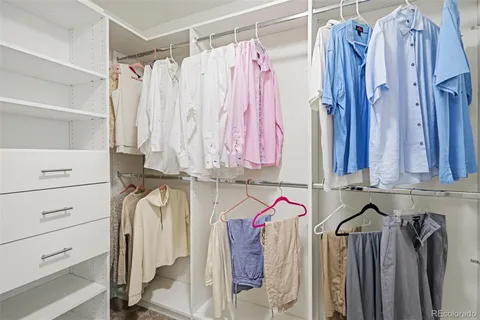 a view of walk in closet with clothes
