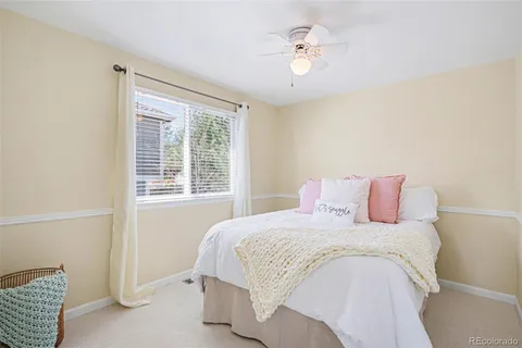 a bedroom with a bed chandelier and a window