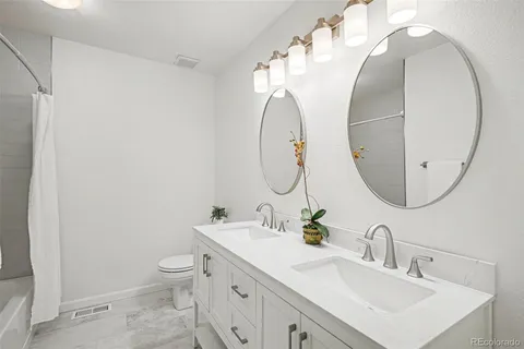 a bathroom with a sink mirror and toilet