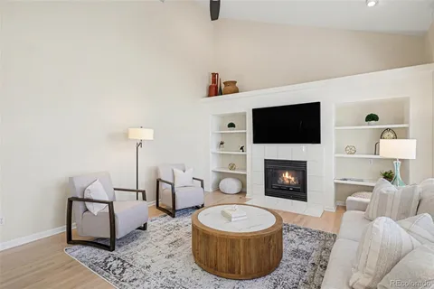 a living room with furniture a fireplace and a flat screen tv