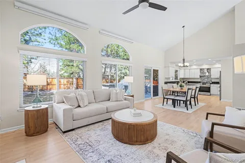 a living room with furniture a table and large window