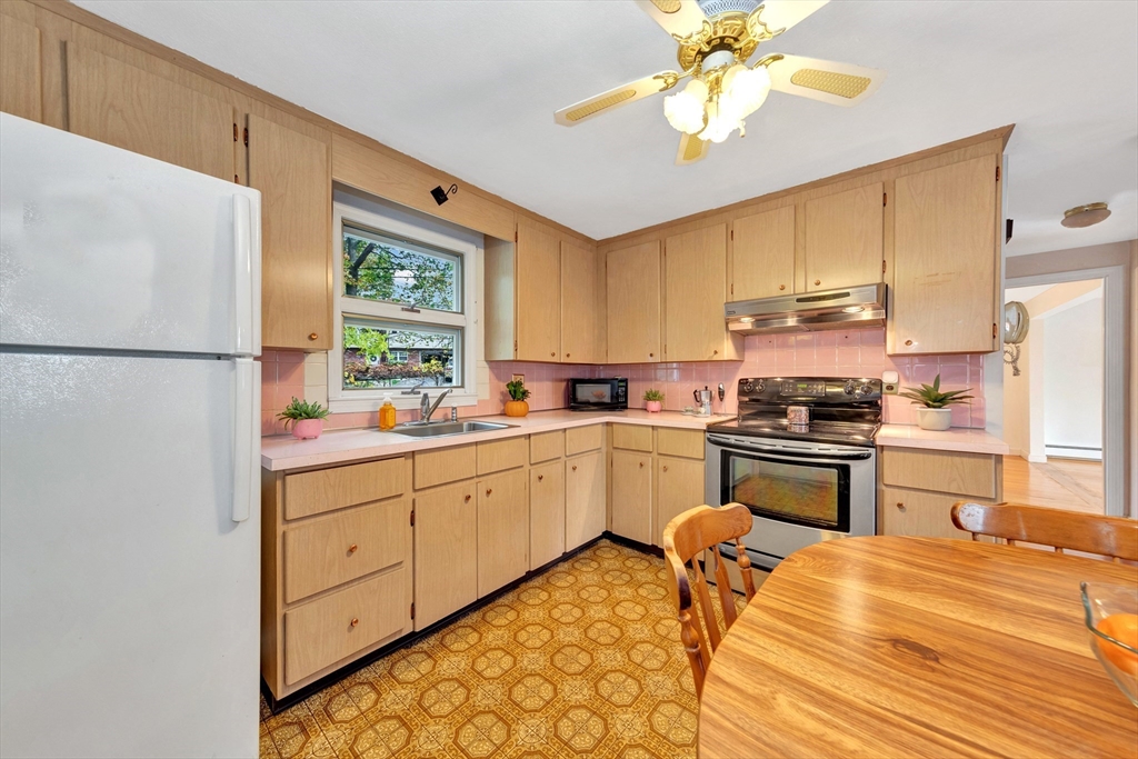 19 Wilbur Avenue Arlington, MA 02476 - Photo 13 of 32 a kitchen with stainless steel appliances white cabinets a sink a stove a refrigerator and island with wooden floor