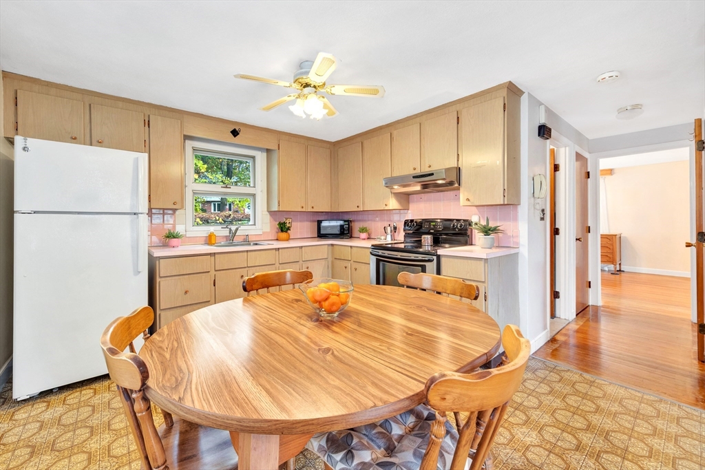 19 Wilbur Avenue Arlington, MA 02476 - Photo 9 of 32 a kitchen with stainless steel appliances a stove a refrigerator a sink a dining table and chairs with wooden floor
