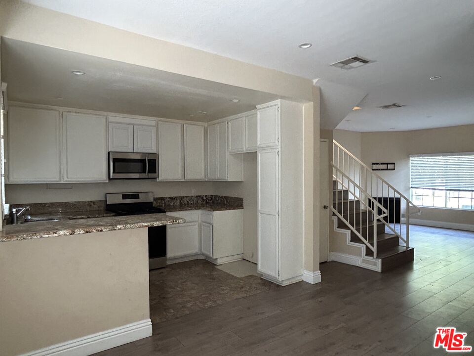 7430 Corbin Avenue, Unit 33 Reseda, CA 91335 - Photo 1 of 28 a kitchen with stainless steel appliances granite countertop a refrigerator and a stove top oven