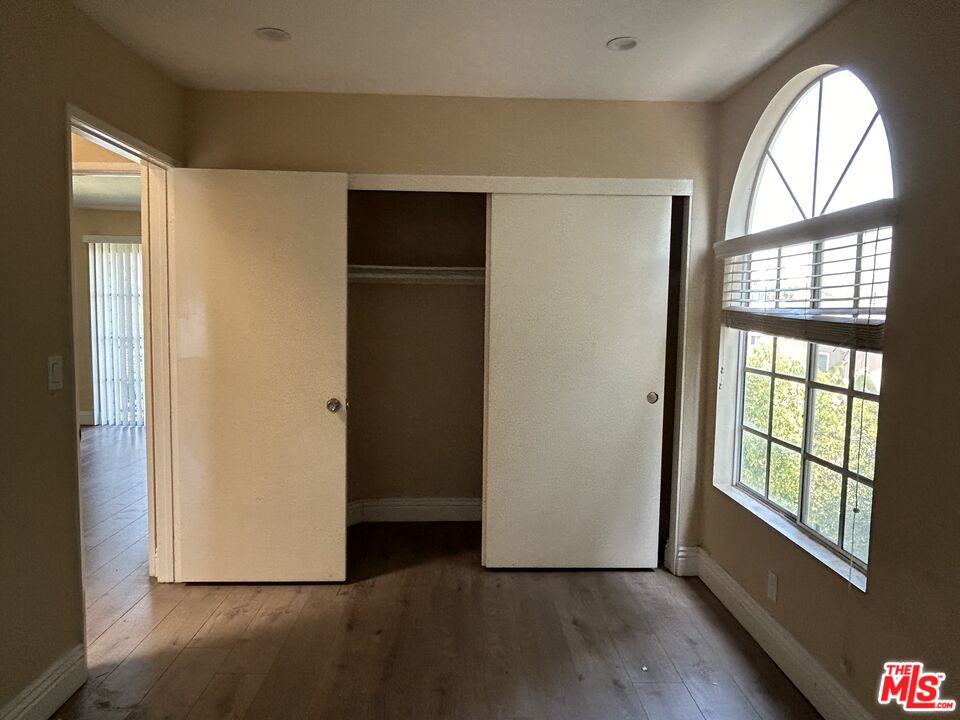 7430 Corbin Avenue, Unit 33 Reseda, CA 91335 - Photo 16 of 28 an empty room with wooden floor cabinet and windows