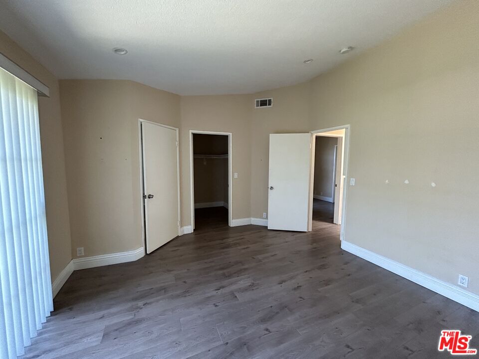 7430 Corbin Avenue, Unit 33 Reseda, CA 91335 - Photo 18 of 28 an empty room with wooden floor and windows