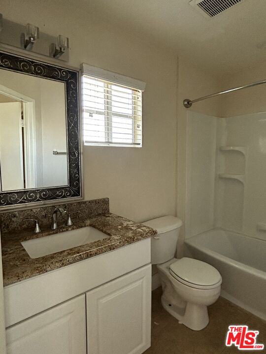 7430 Corbin Avenue, Unit 33 Reseda, CA 91335 - Photo 20 of 28 a bathroom with a granite countertop toilet a sink and a mirror