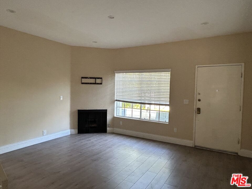 7430 Corbin Avenue, Unit 33 Reseda, CA 91335 - Photo 6 of 28 an empty room with a fireplace and windows