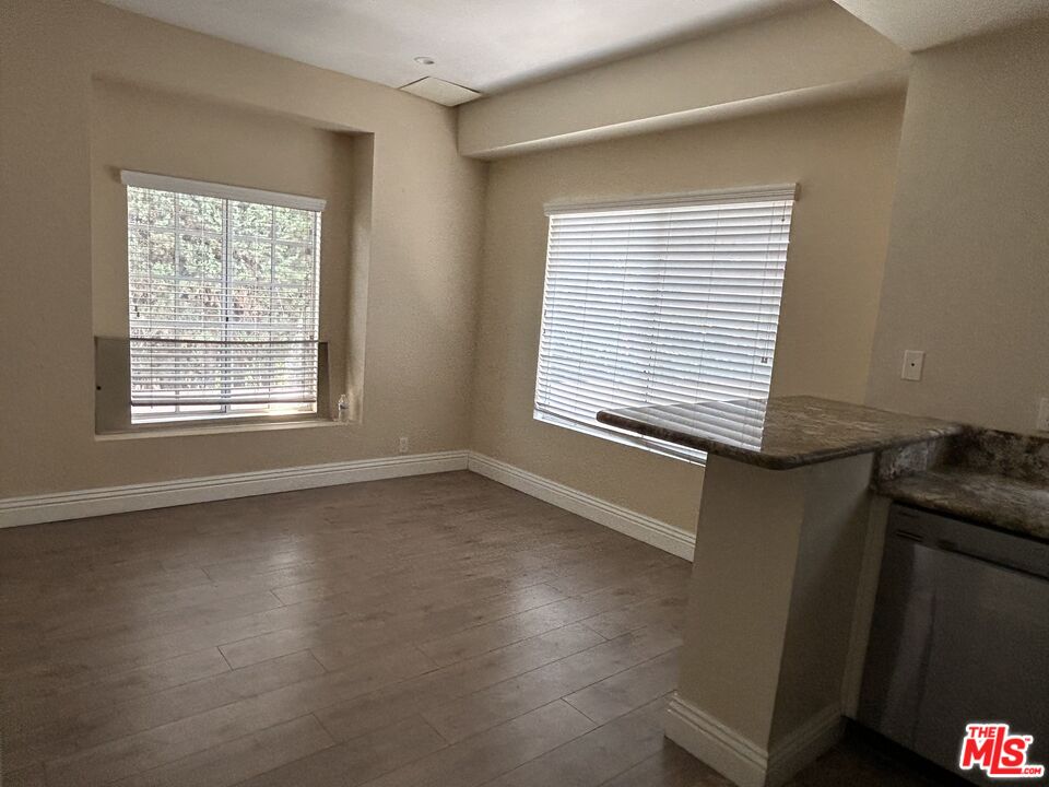 7430 Corbin Avenue, Unit 33 Reseda, CA 91335 - Photo 9 of 28 a view of an empty room with wooden floor and a window
