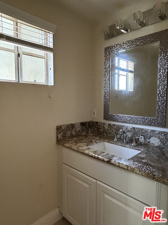 7430 Corbin Avenue, Unit 33 Reseda, CA 91335 - Photo 10 of 28 a bathroom with a granite countertop sink and a mirror