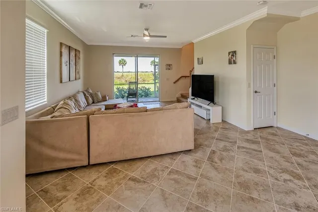 a living room with furniture a flat screen tv and a large window