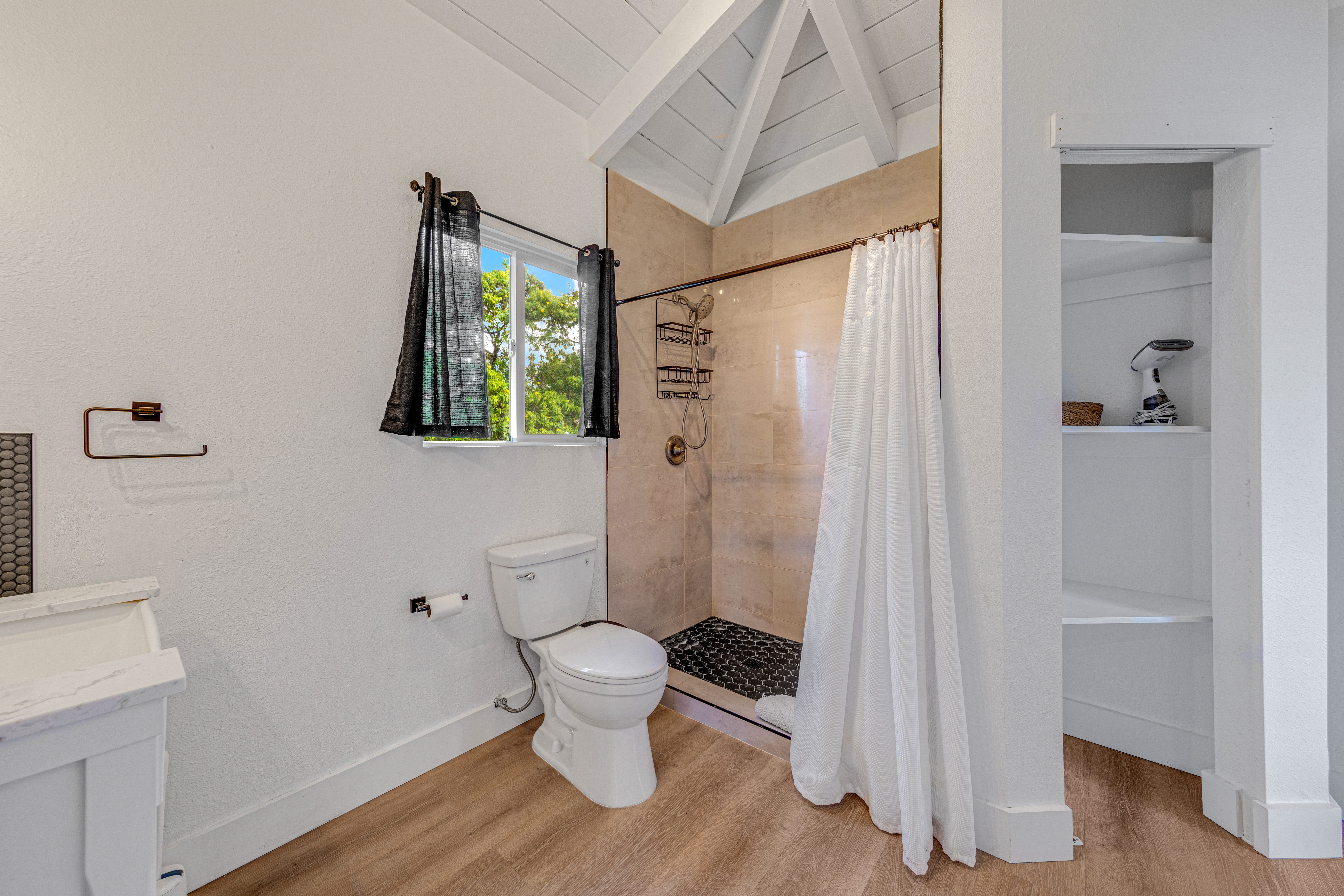 766122 A Royal Poinciana Way, Unit 2 Kailua-Kona, HI 96740 - Photo 20 of 24 a white toilet sitting next to a bathroom sink