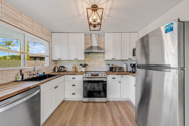 a kitchen with stainless steel appliances a refrigerator sink and cabinets