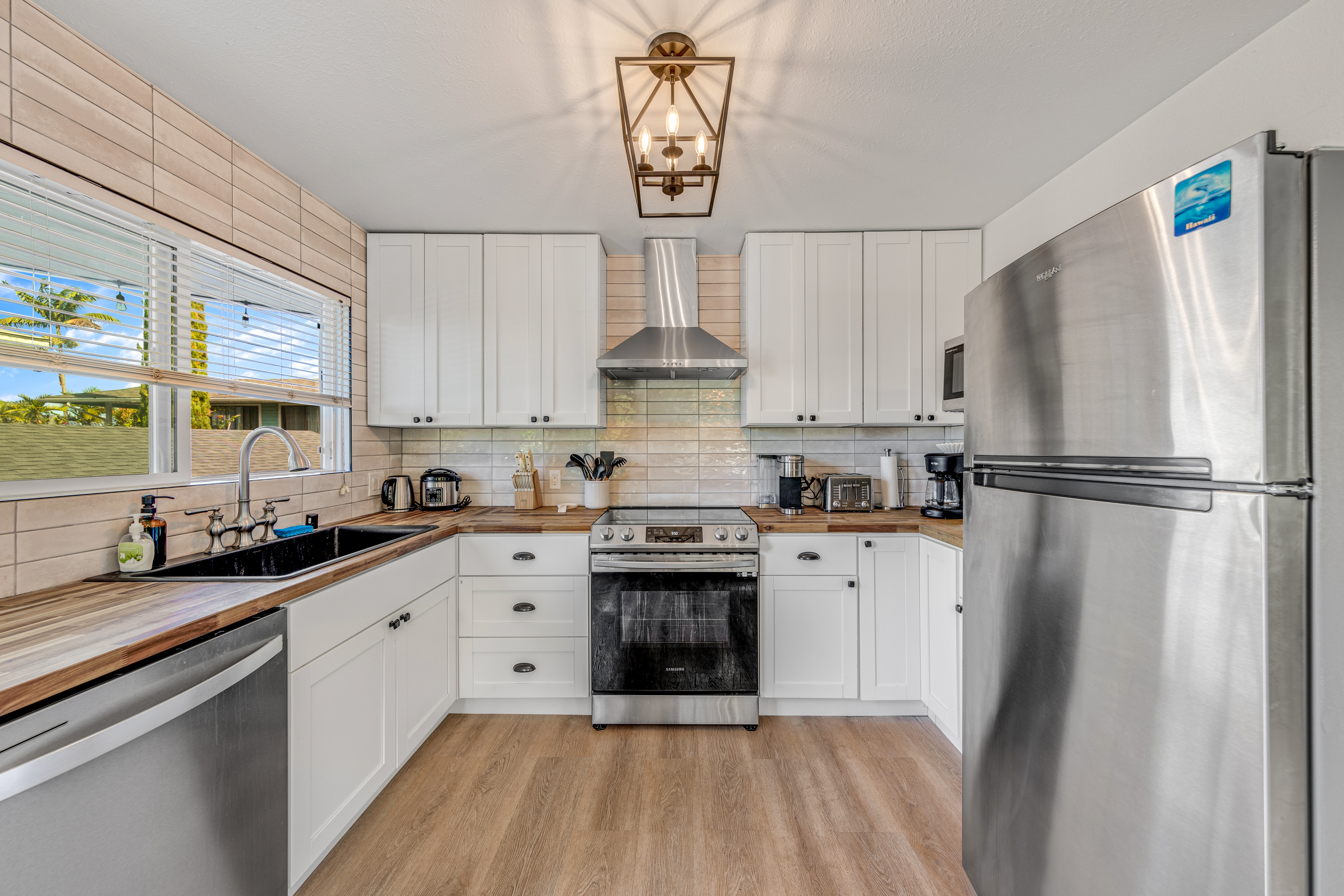 766122 A Royal Poinciana Way, Unit 2 Kailua-Kona, HI 96740 - Photo 2 of 24 a kitchen with stainless steel appliances a refrigerator sink and cabinets