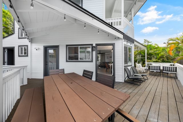 a patio with wooden floor a yard a table and chairs