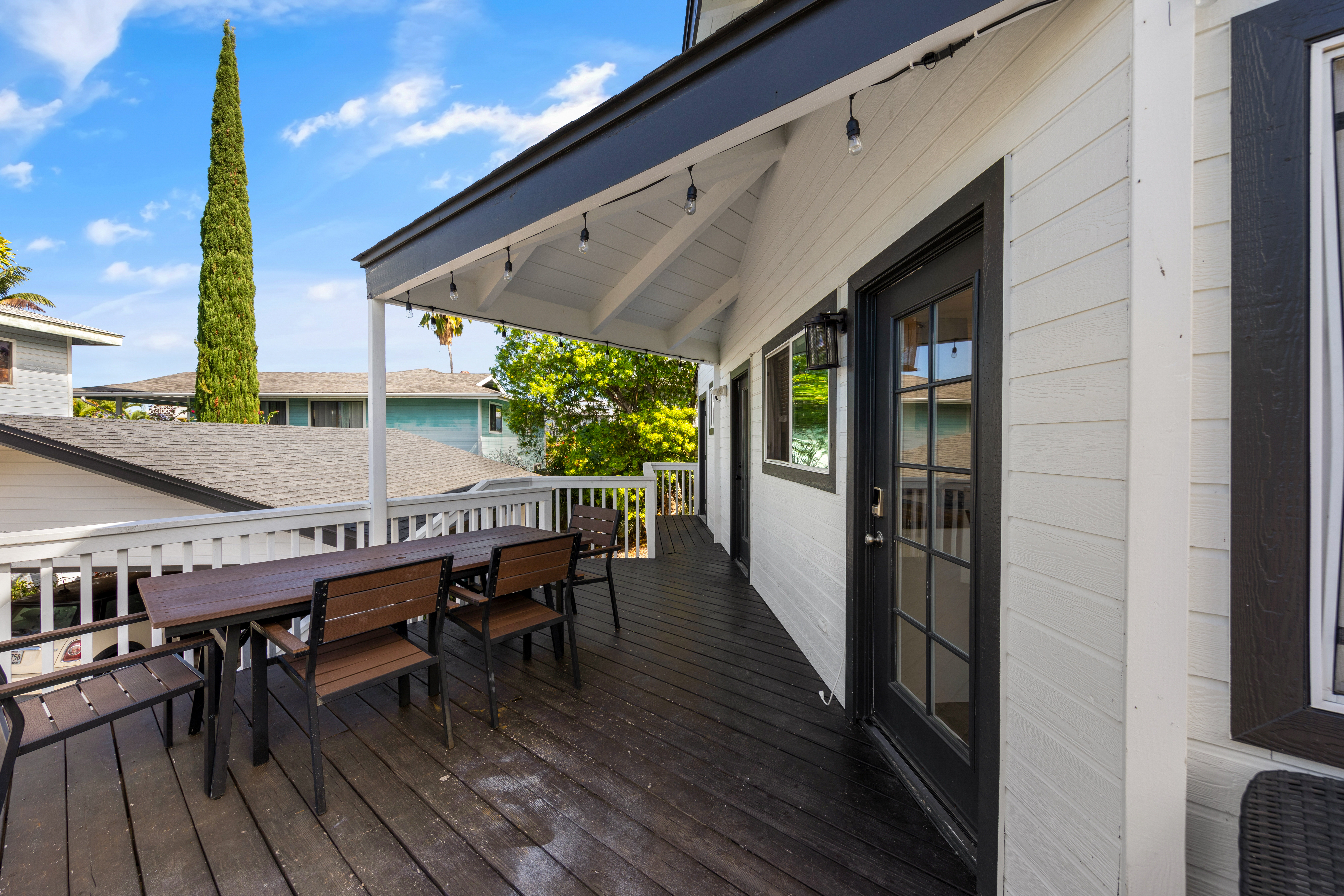 766122 A Royal Poinciana Way, Unit 2 Kailua-Kona, HI 96740 - Photo 6 of 24 a patio with wooden floor a yard a table and chairs