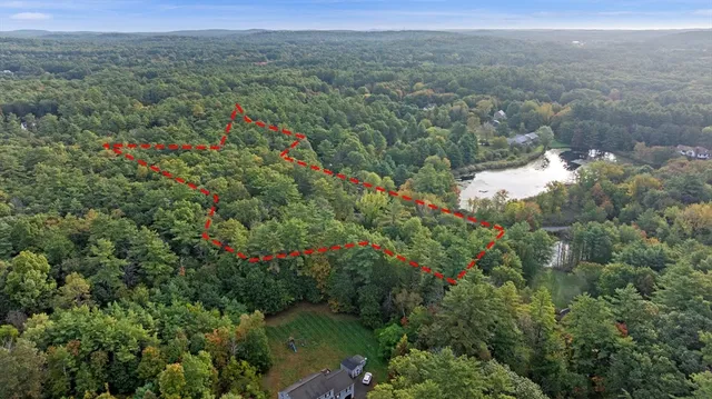 an aerial view of residential house with outdoor space and trees all around