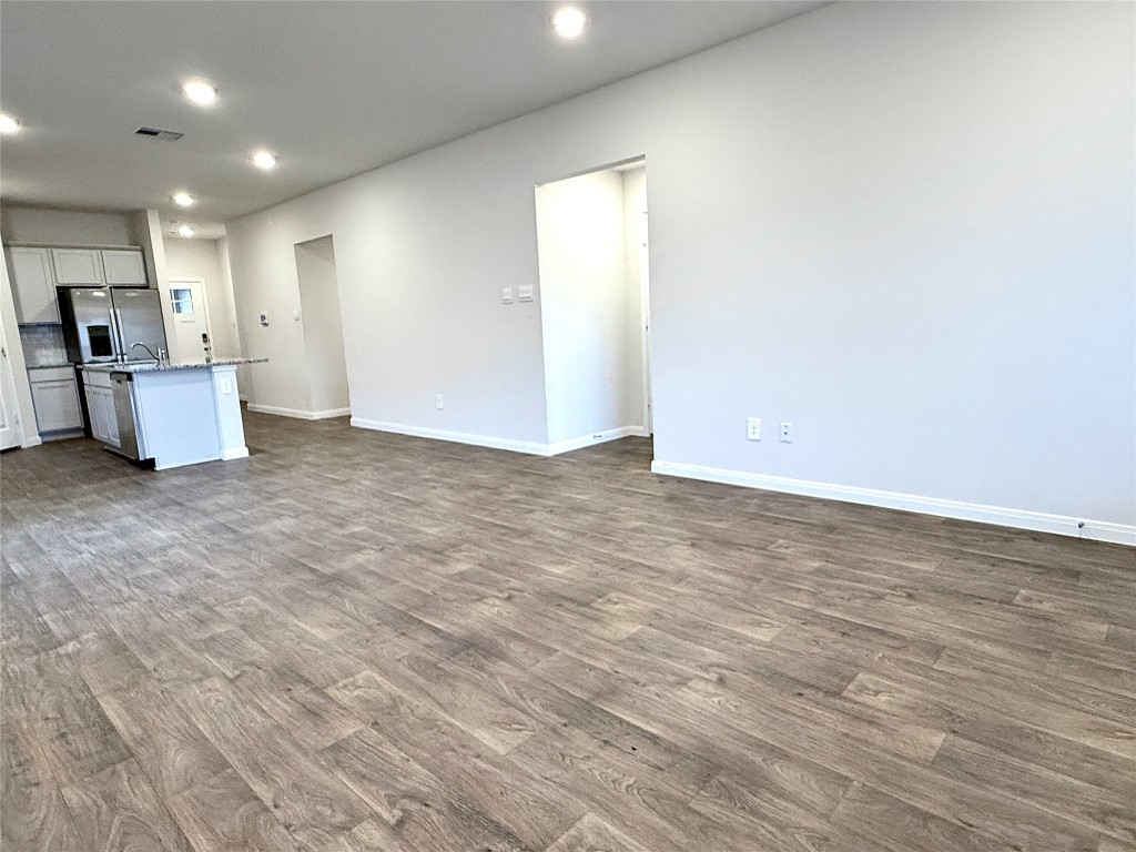 1305 Middleton Grove Lockhart, TX 78644 - Photo 10 of 19 wooden floor in an empty room with a kitchen