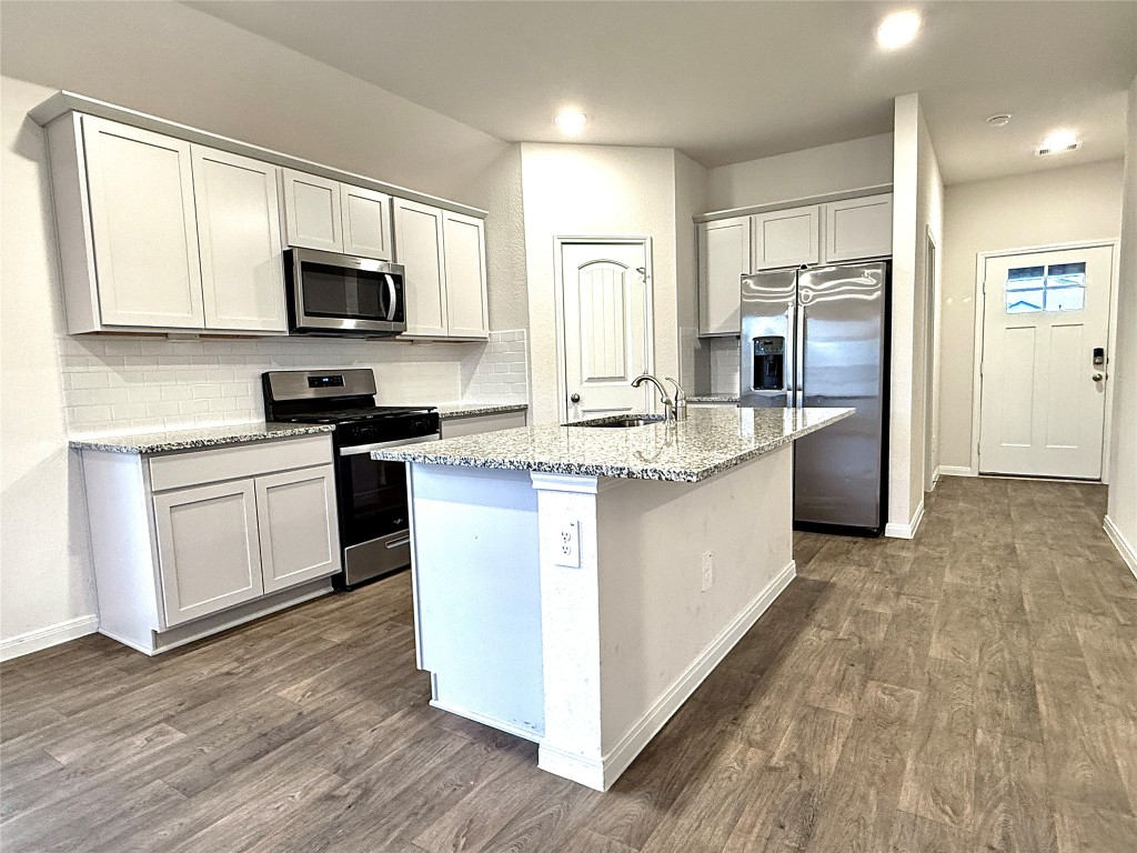 1305 Middleton Grove Lockhart, TX 78644 - Photo 3 of 19 a kitchen with stainless steel appliances granite countertop a stove a sink dishwasher a refrigerator and a microwave