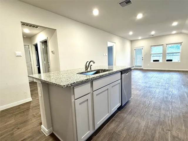 a kitchen with stainless steel appliances granite countertop a stove a sink dishwasher a refrigerator and a microwave