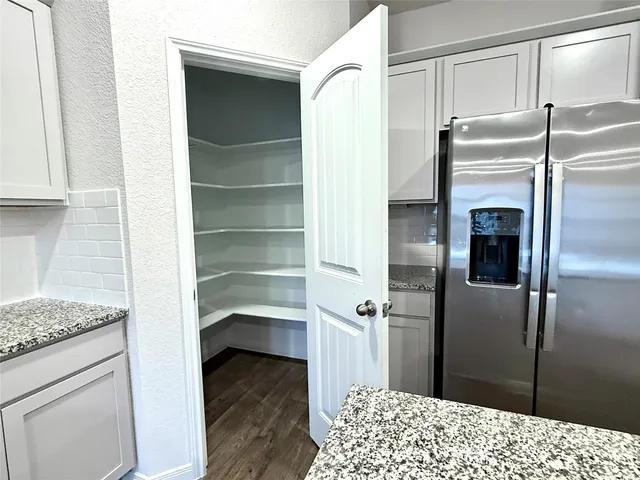a kitchen with granite countertop wooden cabinets and a stove top oven