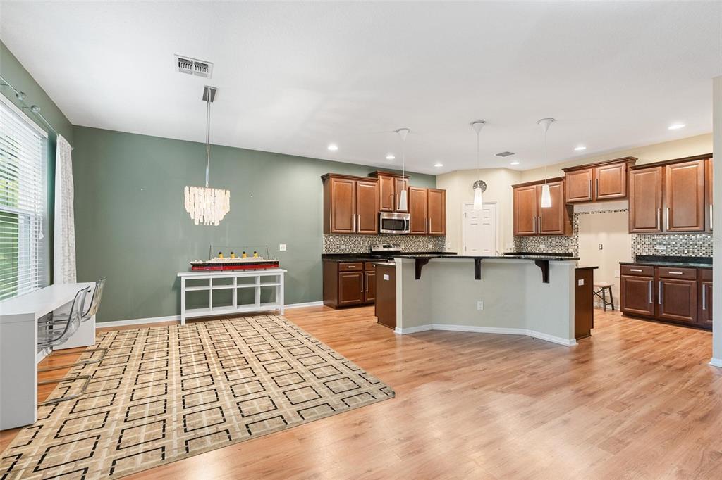 6799 Helmsley Circle Windermere, FL 34786 - Photo 11 of 61 a kitchen with stainless steel appliances kitchen island granite countertop a stove top oven a sink a counter space and cabinets