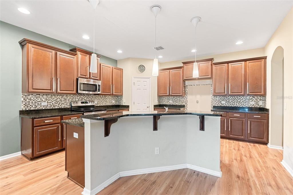 6799 Helmsley Circle Windermere, FL 34786 - Photo 12 of 61 a kitchen with stainless steel appliances granite countertop wooden cabinets a stove top oven and a granite counter tops