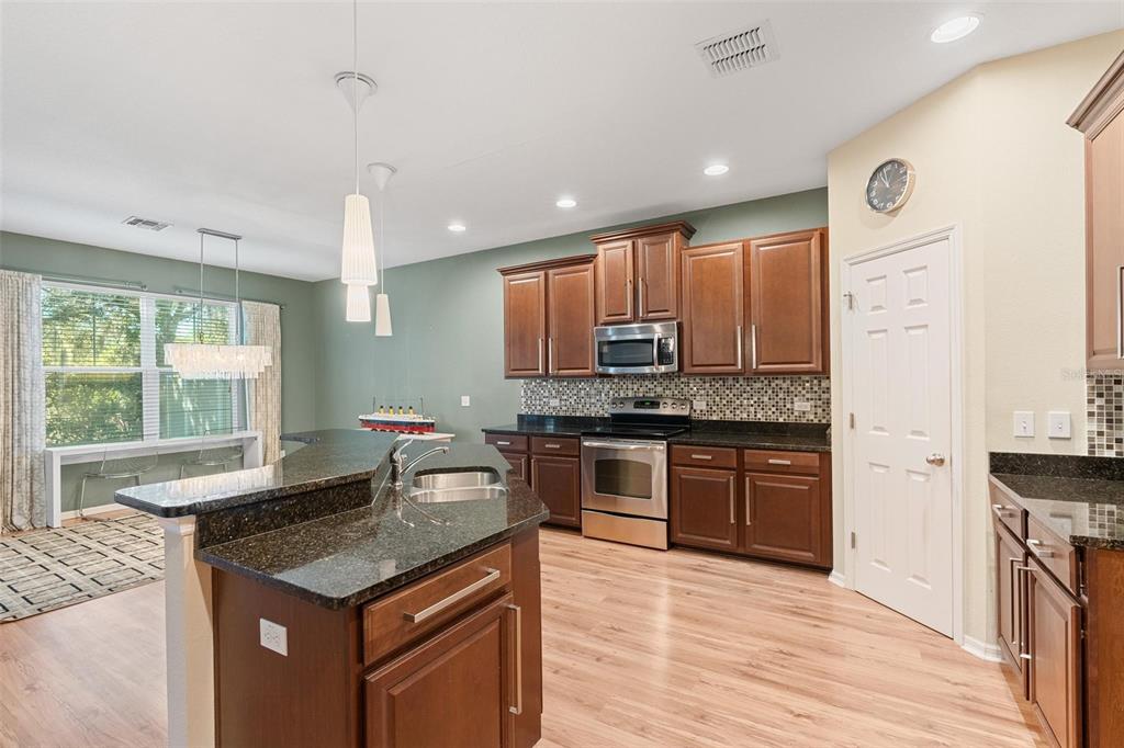 6799 Helmsley Circle Windermere, FL 34786 - Photo 16 of 61 a kitchen with stainless steel appliances granite countertop wooden cabinets a stove a sink and a wooden floors