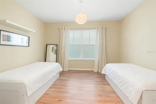 a bedroom with a bed table and a flat screen tv