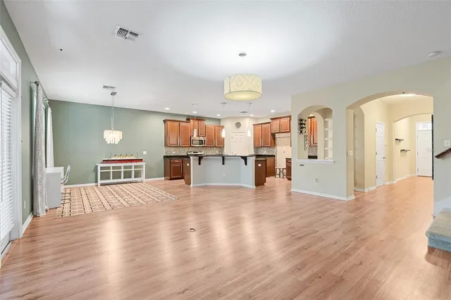a view of a living room a kitchen with furniture and wooden floor
