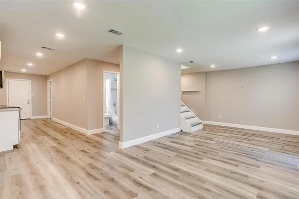 a view of an empty room with wooden floor