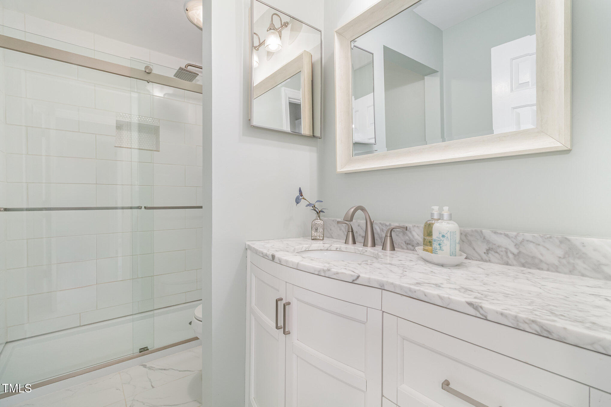 7050 Sandy Forks Road, Unit 101 Raleigh, NC 27615 - Photo 18 of 23 a bathroom with a granite countertop sink and a mirror