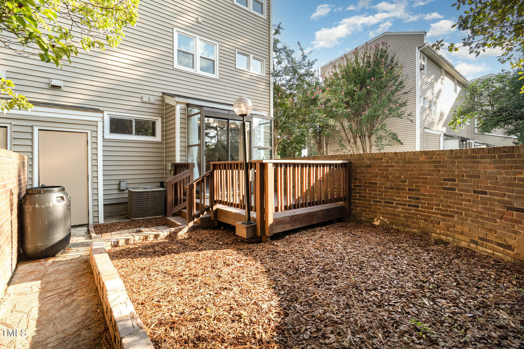7050 Sandy Forks Road, Unit 101 Raleigh, NC 27615 - Photo 20 of 23 a view of backyard with a deck and outdoor seating