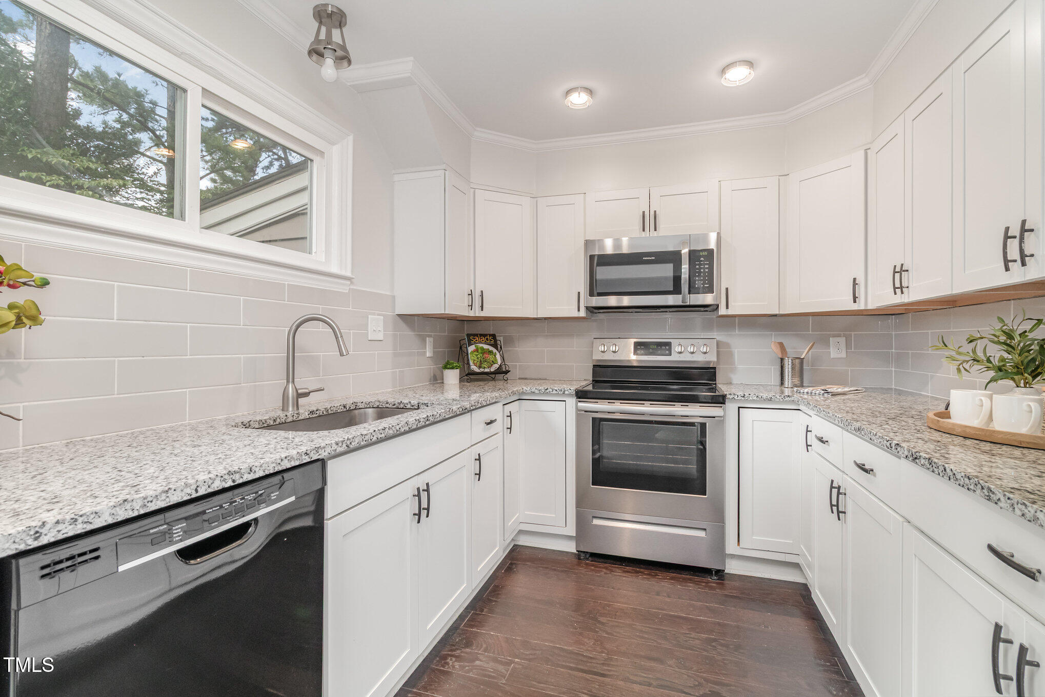 7050 Sandy Forks Road, Unit 101 Raleigh, NC 27615 - Photo 7 of 23 a kitchen with granite countertop a sink stainless steel appliances and cabinets