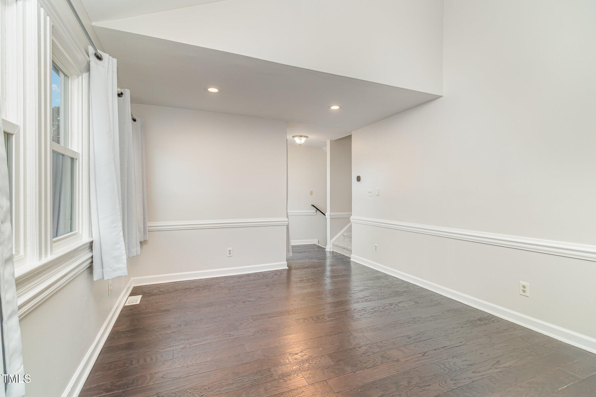 7050 Sandy Forks Road, Unit 101 Raleigh, NC 27615 - Photo 10 of 23 a view of an empty room with wooden floor and a window