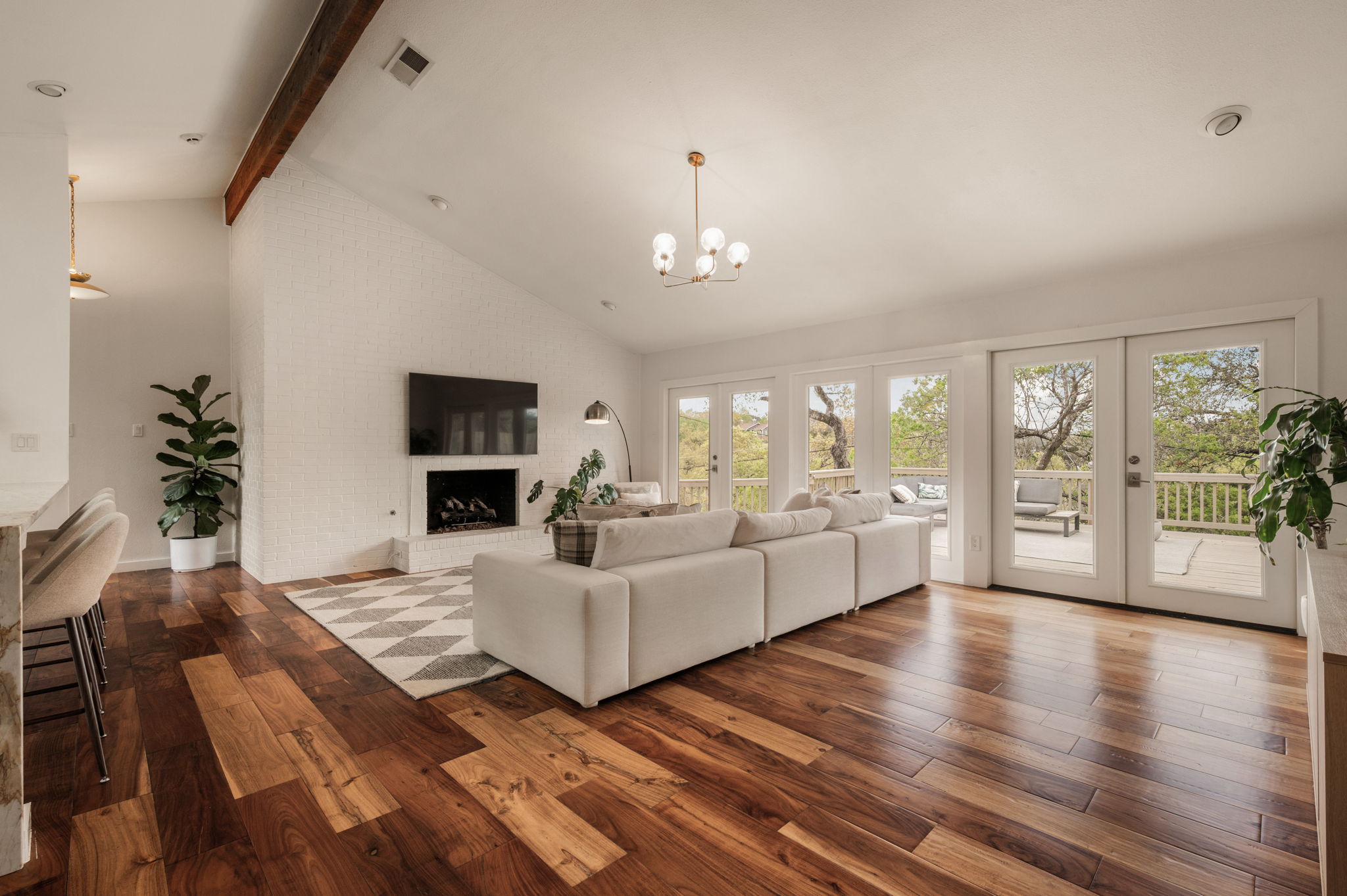 6501 Sumac Drive Austin, TX 78731 - Photo 7 of 40 Living room featuring dark wood-style flooring, vaulted ceiling, french doors, a large fireplace, and a chandelier