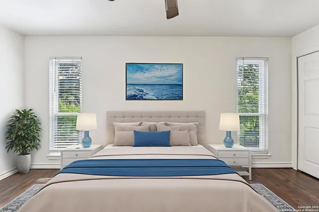 a bedroom with a large bed and a potted plant