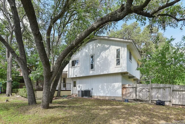 a large tree in the garden in front of a house