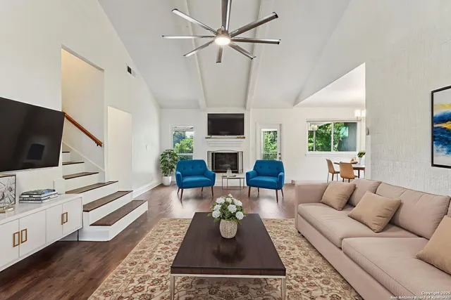 a living room with furniture a fireplace and a flat screen tv