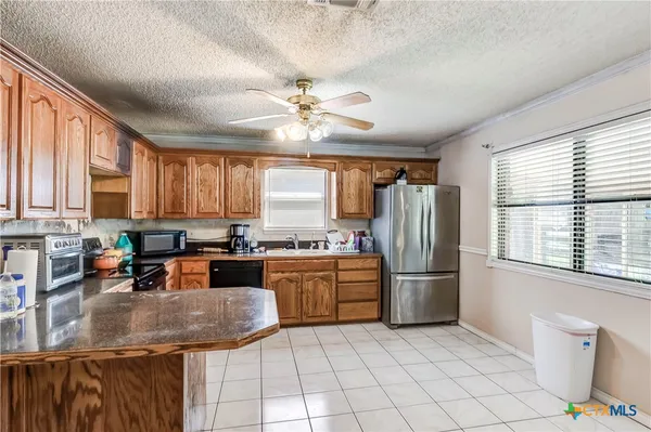 a kitchen with refrigerator cabinets and large window