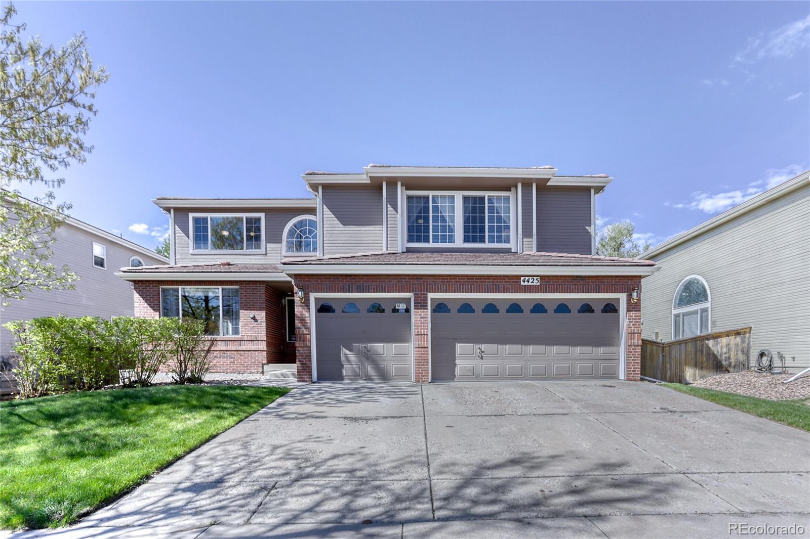 4425 Iran Street Denver, CO 80249 - Photo 1 of 36 a front view of a house with a yard and garage