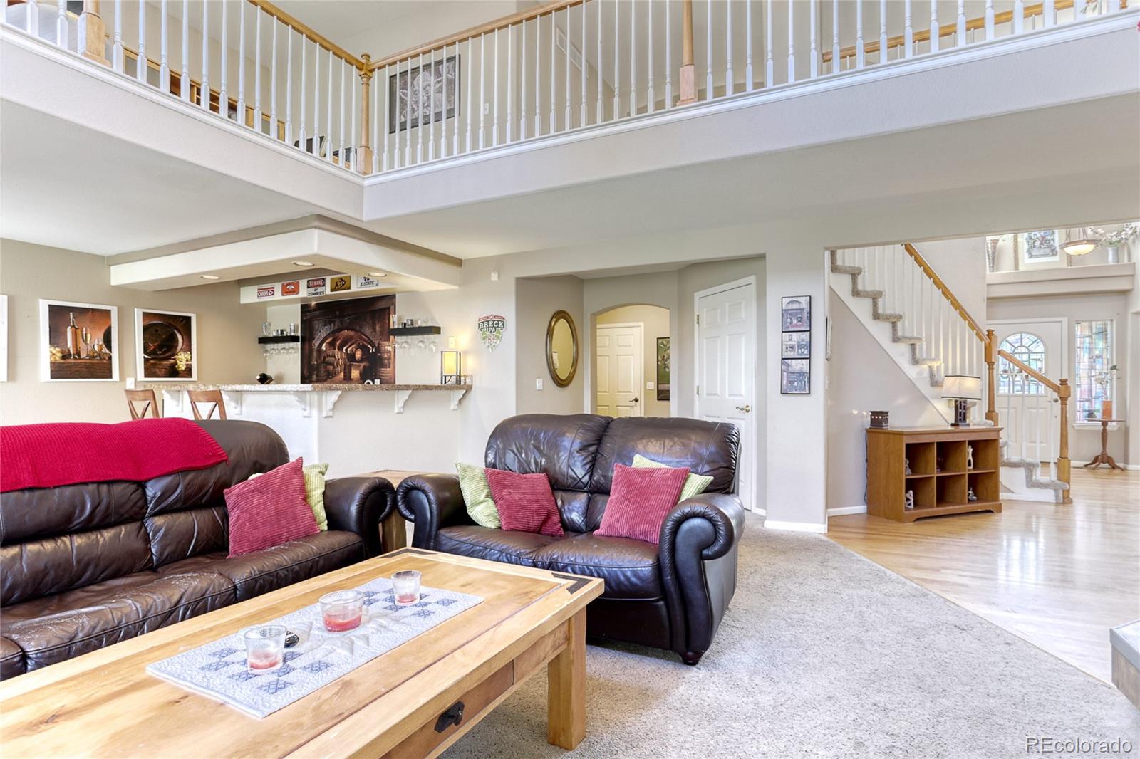 4425 Iran Street Denver, CO 80249 - Photo 13 of 36 a living room with furniture a rug and kitchen view